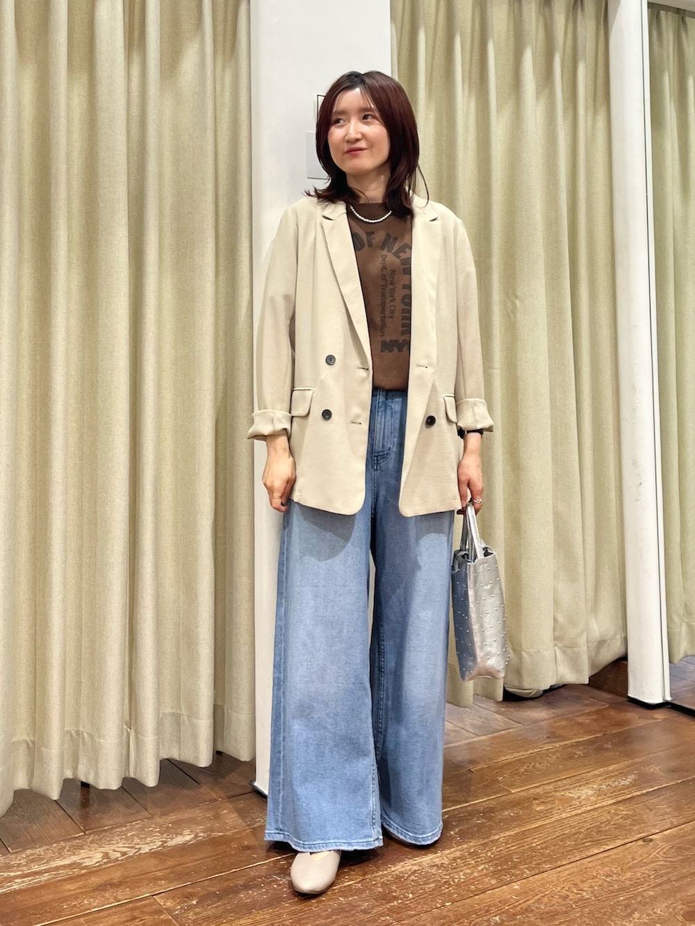 ベージュ系のその他アウター、ブルー系のデニムパンツ、ベージュ系のパンプスを着用したレディースの春コーディネートの2枚目の写真