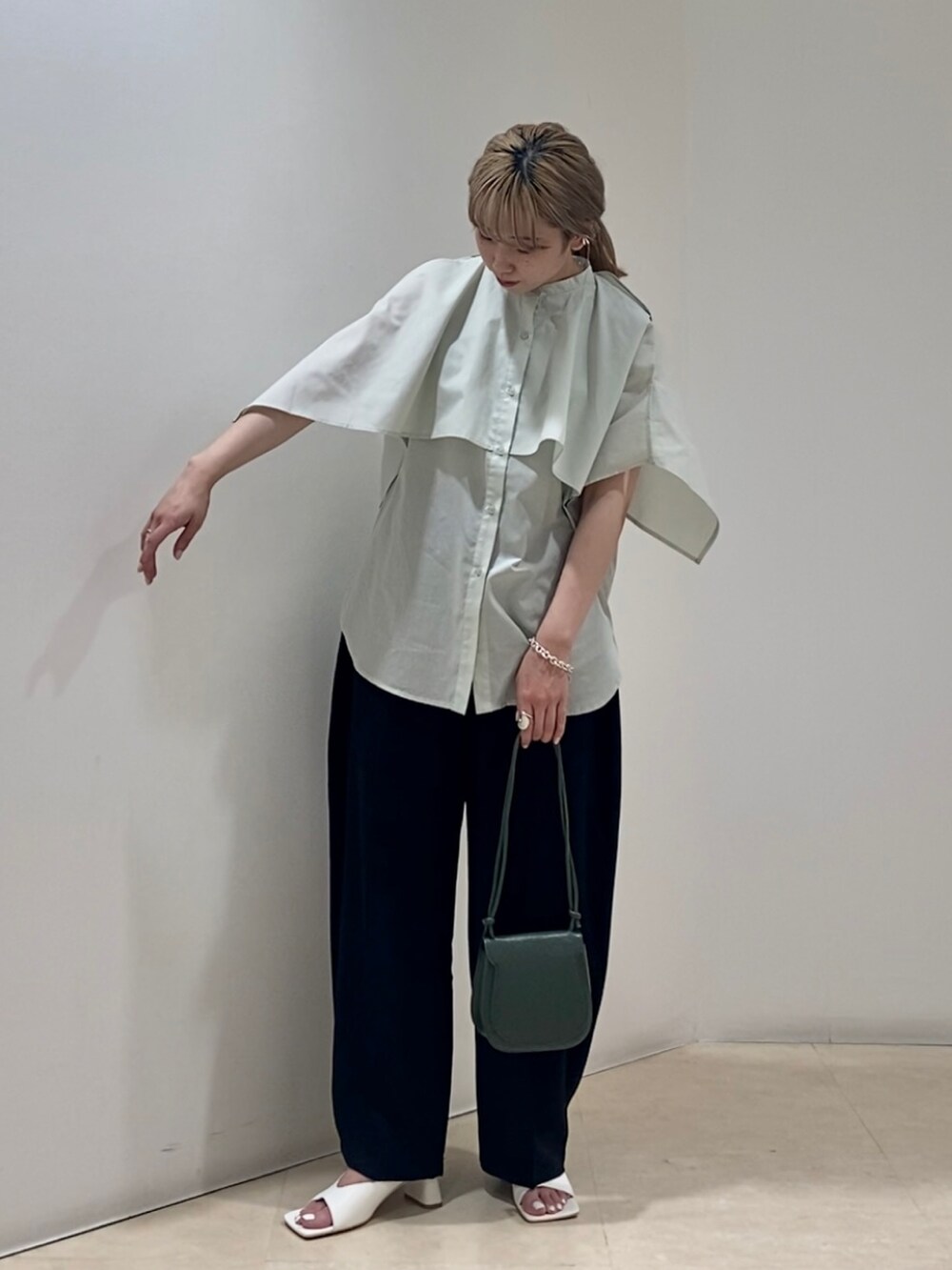 グリーン系のシャツ/ブラウス、ブラック系のその他パンツ、グリーン系のショルダーバッグを着用したレディースの春コーディネートの2枚目の写真