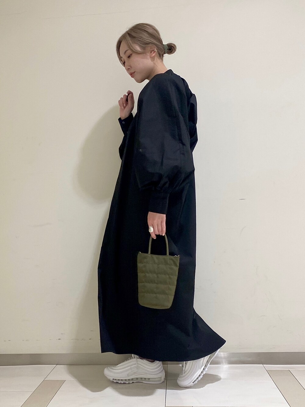 ブラック系のワンピース、グリーン系のショルダーバッグを着用したレディースの冬コーディネートの3枚目の写真