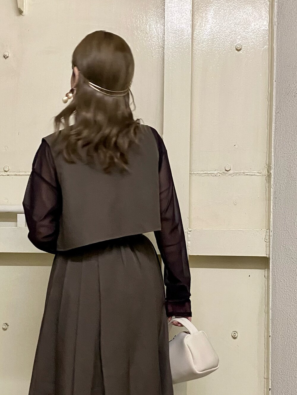 ブラウン系のワンピース、ホワイト系のハンドバッグ、レッド系のTシャツ/カットソーを着用したレディースの秋コーディネートの2枚目の写真