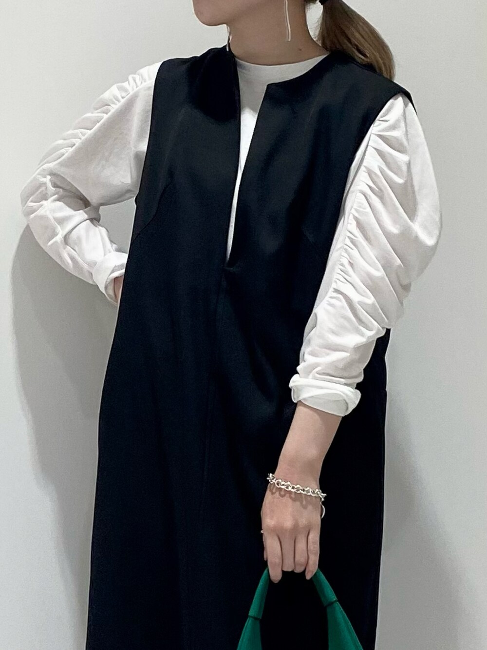 ブラック系のワンピース、ホワイト系のTシャツ/カットソー、グリーン系のトートバッグを着用したレディースの春コーディネートの2枚目の写真