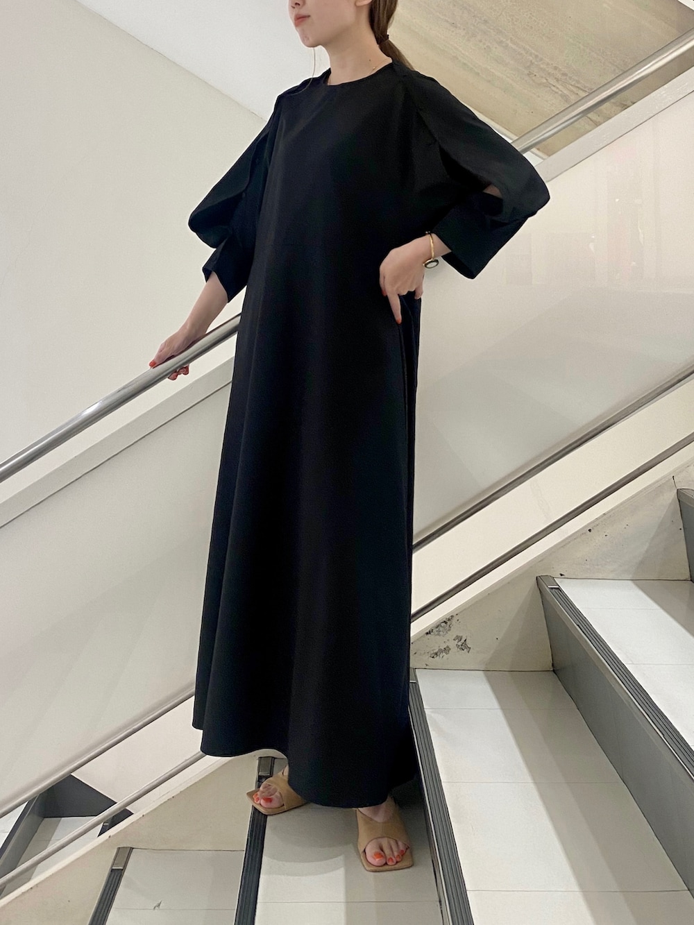 ブラック系のワンピース、イエロー系のサンダルを着用したレディースの夏コーディネートの2枚目の写真