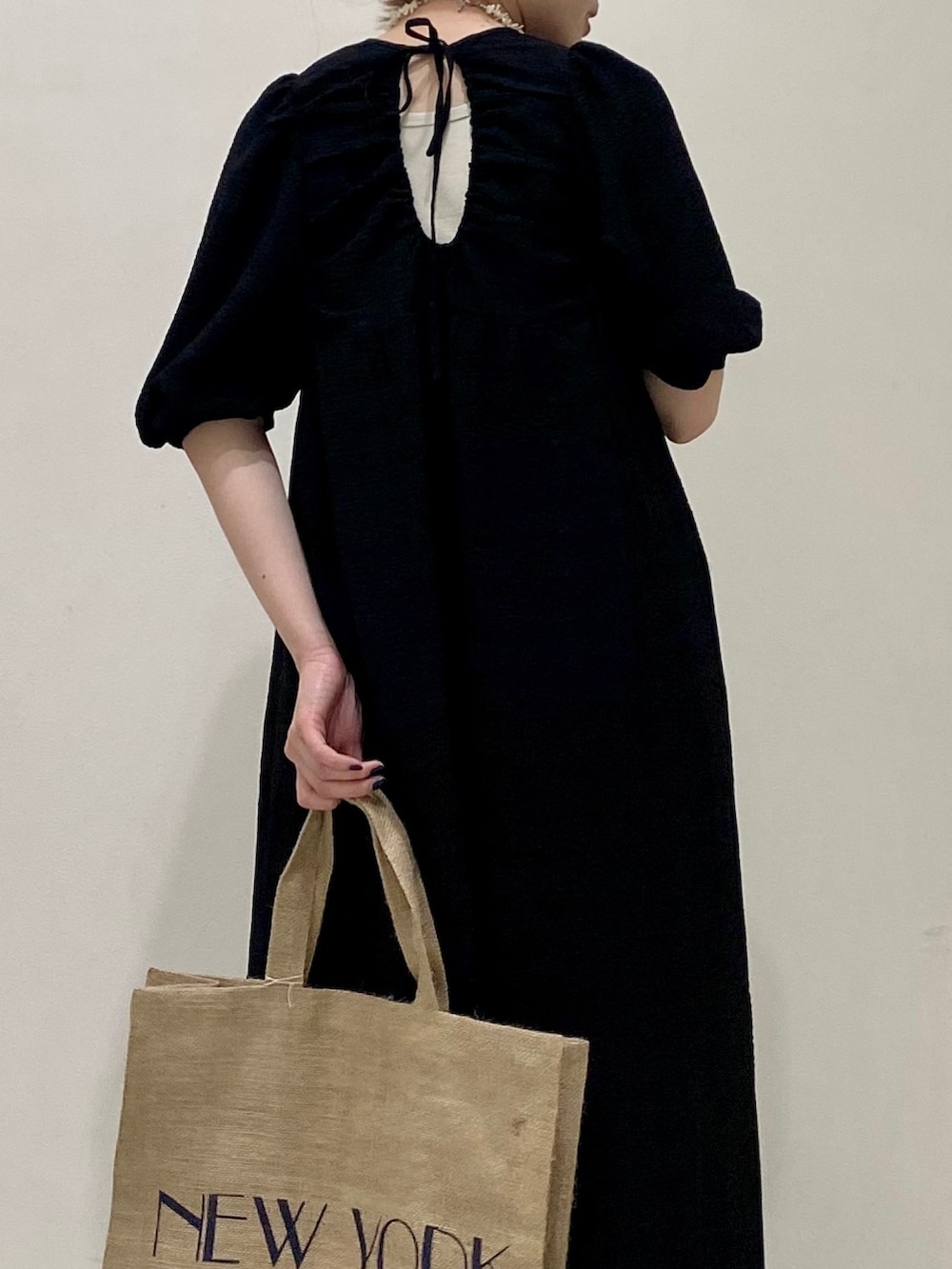 ブラック系のワンピース、ホワイト系のネックレスを着用したレディースの春コーディネートの2枚目の写真