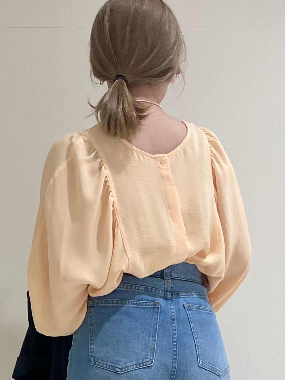 オレンジ系のシャツ/ブラウス、ブルー系のデニムパンツ、ブラウン系のパンプスを着用したレディースの春コーディネートの3枚目の写真
