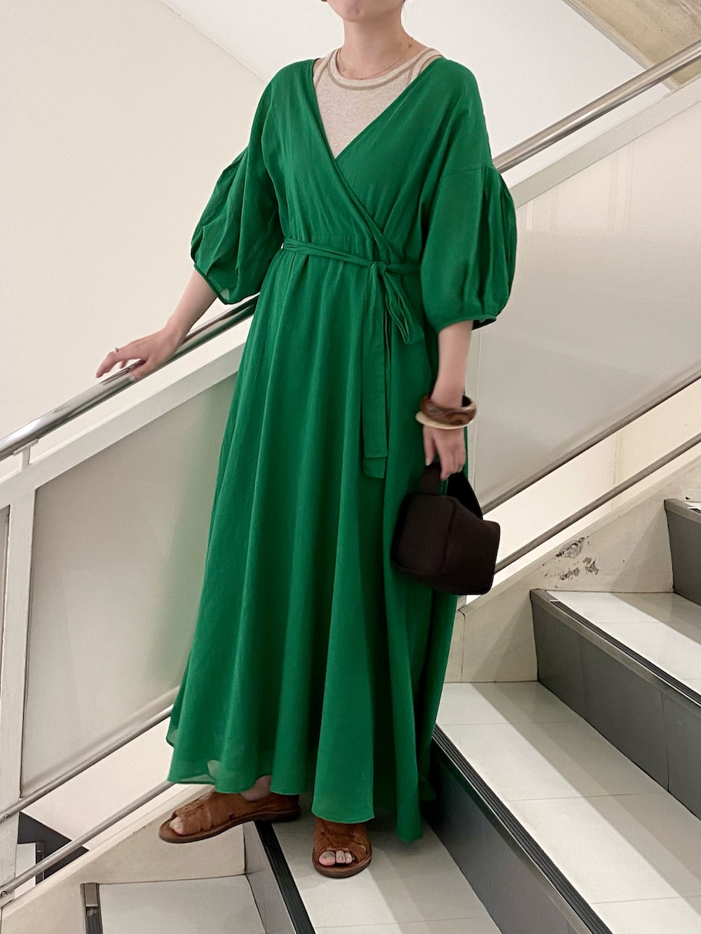 グリーン系のワンピース、ベージュ系のタンクトップ、ブラウン系のハンドバッグを着用したレディースの夏コーディネートの2枚目の写真