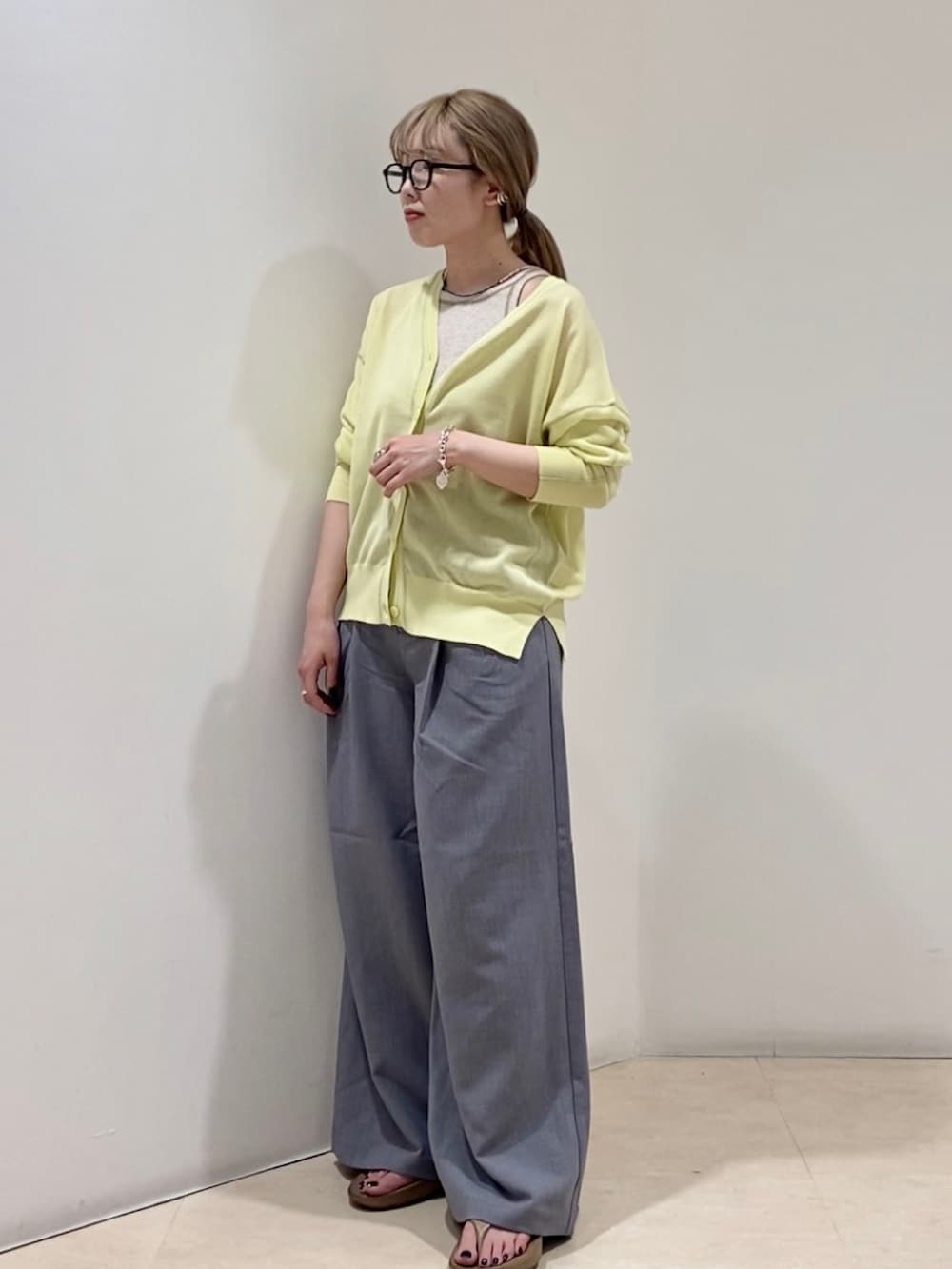 イエロー系のカーディガン/ボレロ、ベージュ系のタンクトップ、グレー系のその他パンツを着用したレディースの春コーディネートの2枚目の写真