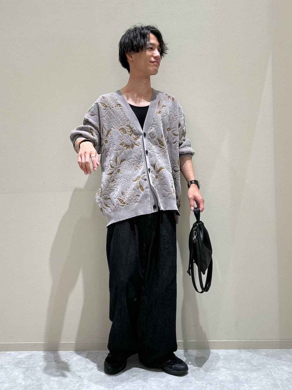 ブラック系のショルダーバッグ、ブラック系のデニムパンツ、グレー系のカーディガン/ボレロを着用したメンズの秋コーディネートの2枚目の写真
