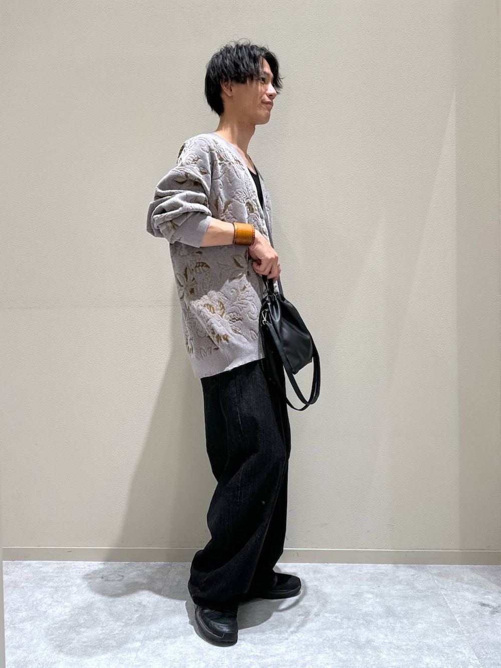ブラック系のショルダーバッグ、ブラック系のデニムパンツ、グレー系のカーディガン/ボレロを着用したメンズの秋コーディネートの3枚目の写真