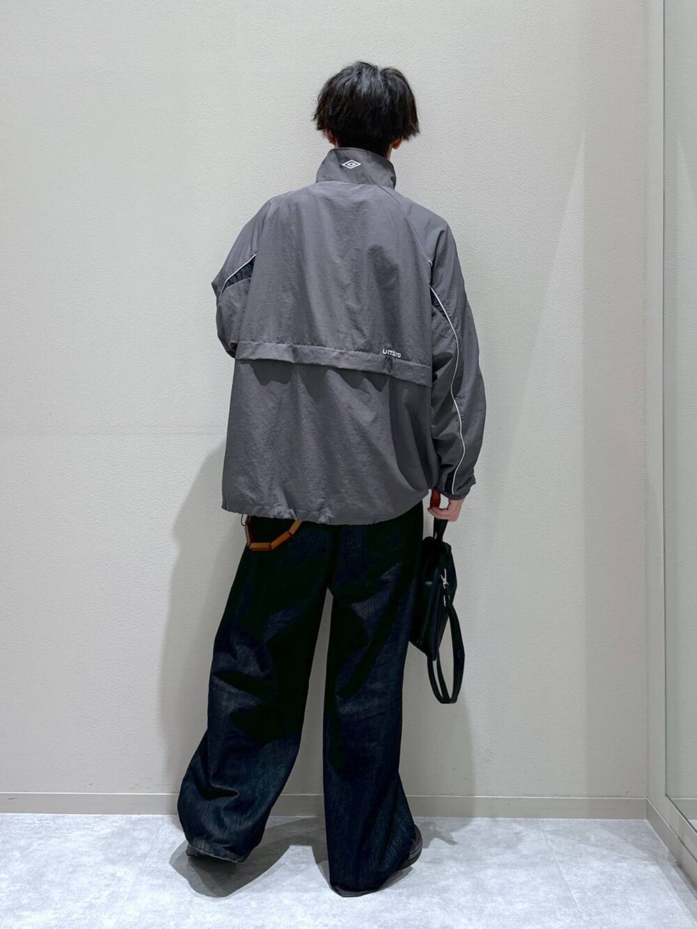 ブラック系のショルダーバッグ、ブラック系のデニムパンツを着用したメンズの秋コーディネートの3枚目の写真