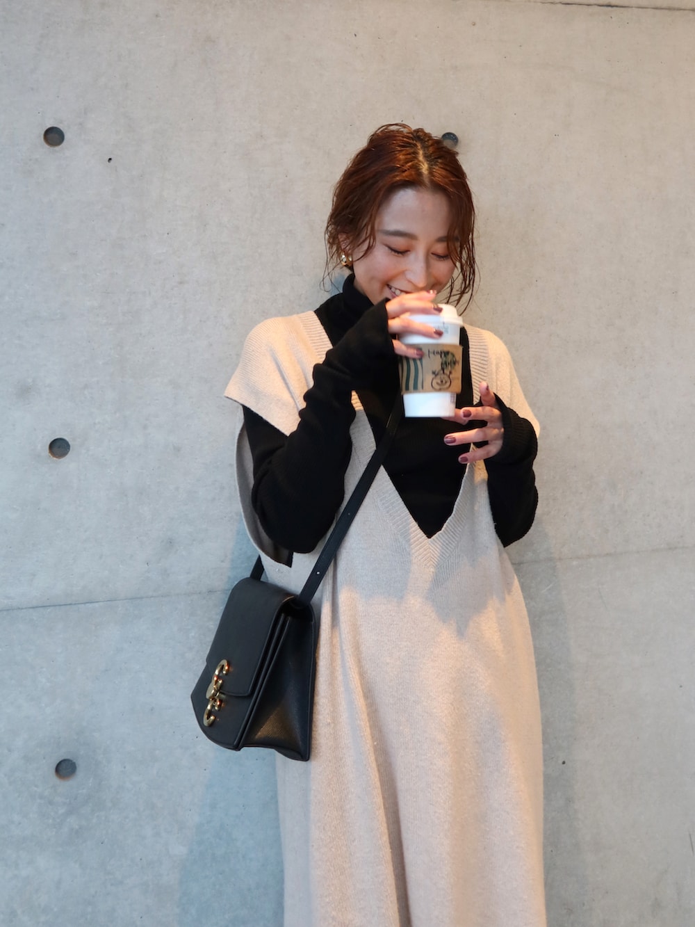 ブラック系のニット/セーター、ベージュ系のワンピース、ブラック系のバッグを着用したレディースの冬コーディネートの2枚目の写真