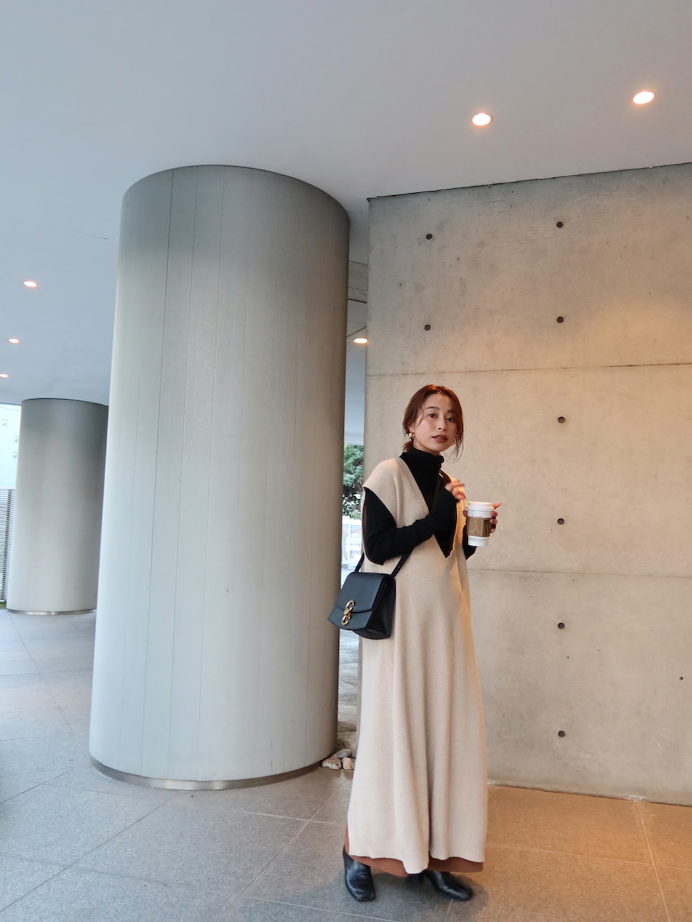 ブラック系のニット/セーター、ベージュ系のワンピース、ブラック系のバッグを着用したレディースの冬コーディネートの3枚目の写真