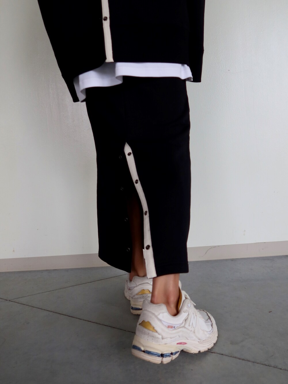 ブラック系のスウェット、ブラック系のスカート、ホワイト系のスニーカーを着用したレディースの冬コーディネートの3枚目の写真