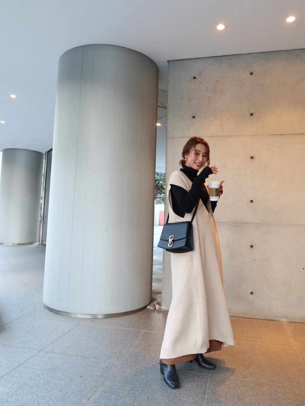 ブラック系のニット/セーター、ベージュ系のワンピース、ブラック系のバッグを着用したレディースの冬コーディネートの4枚目の写真