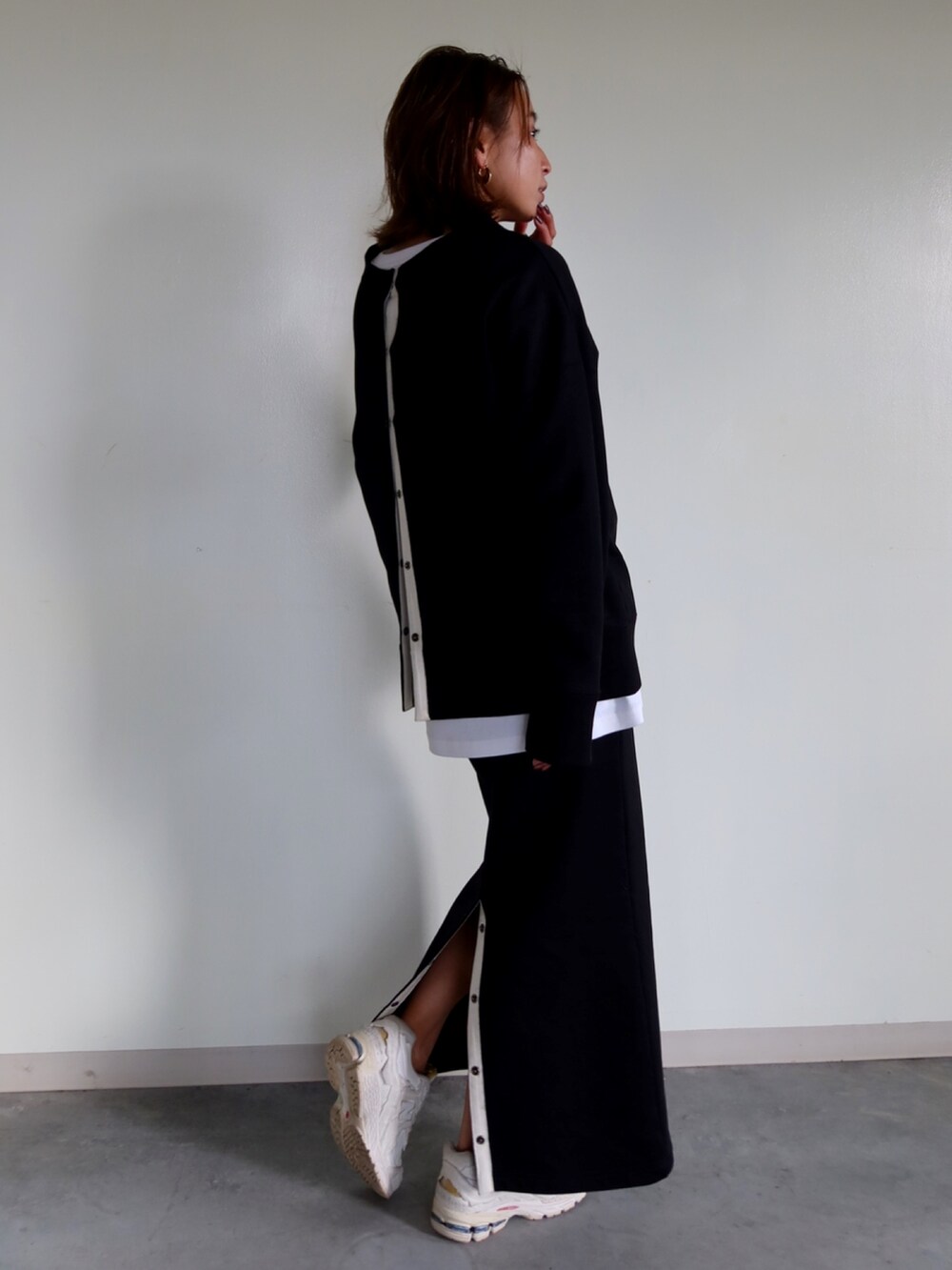 ブラック系のスウェット、ブラック系のスカート、ホワイト系のスニーカーを着用したレディースの冬コーディネートの5枚目の写真