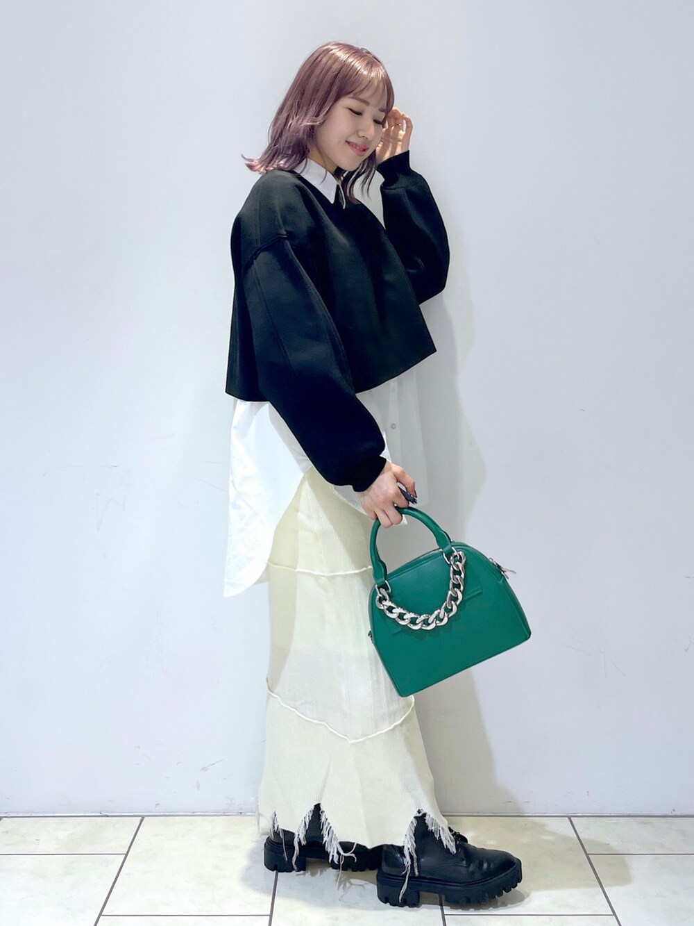 ホワイト系のシャツ/ブラウス、ブラック系のニット/セーター、ホワイト系のスカートを着用したレディースの冬コーディネートの2枚目の写真