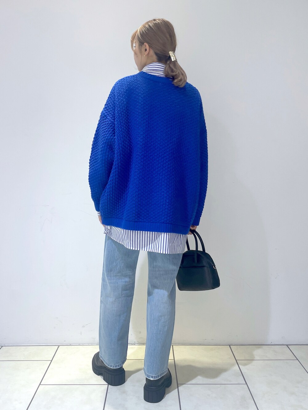 ブルー系のシャツ/ブラウス、ブルー系のニット/セーター、ブルー系のデニムパンツを着用したレディースの冬コーディネートの3枚目の写真