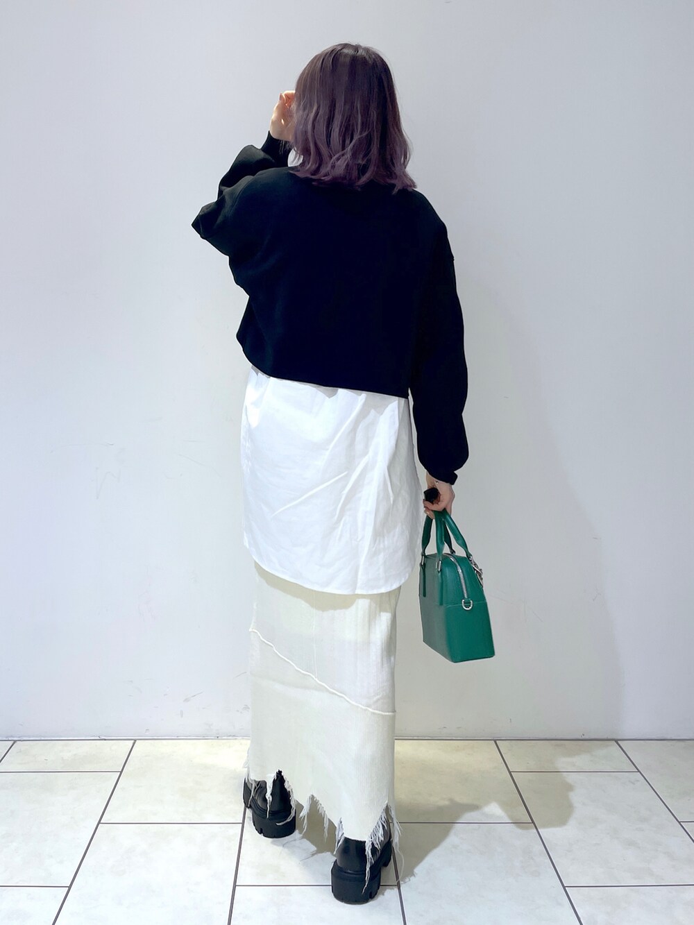 ホワイト系のシャツ/ブラウス、ブラック系のニット/セーター、ホワイト系のスカートを着用したレディースの冬コーディネートの3枚目の写真