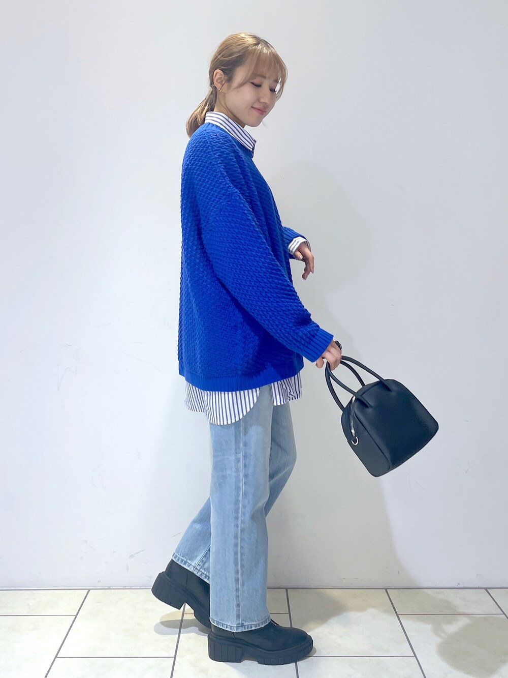 ブルー系のシャツ/ブラウス、ブルー系のニット/セーター、ブルー系のデニムパンツを着用したレディースの冬コーディネートの2枚目の写真