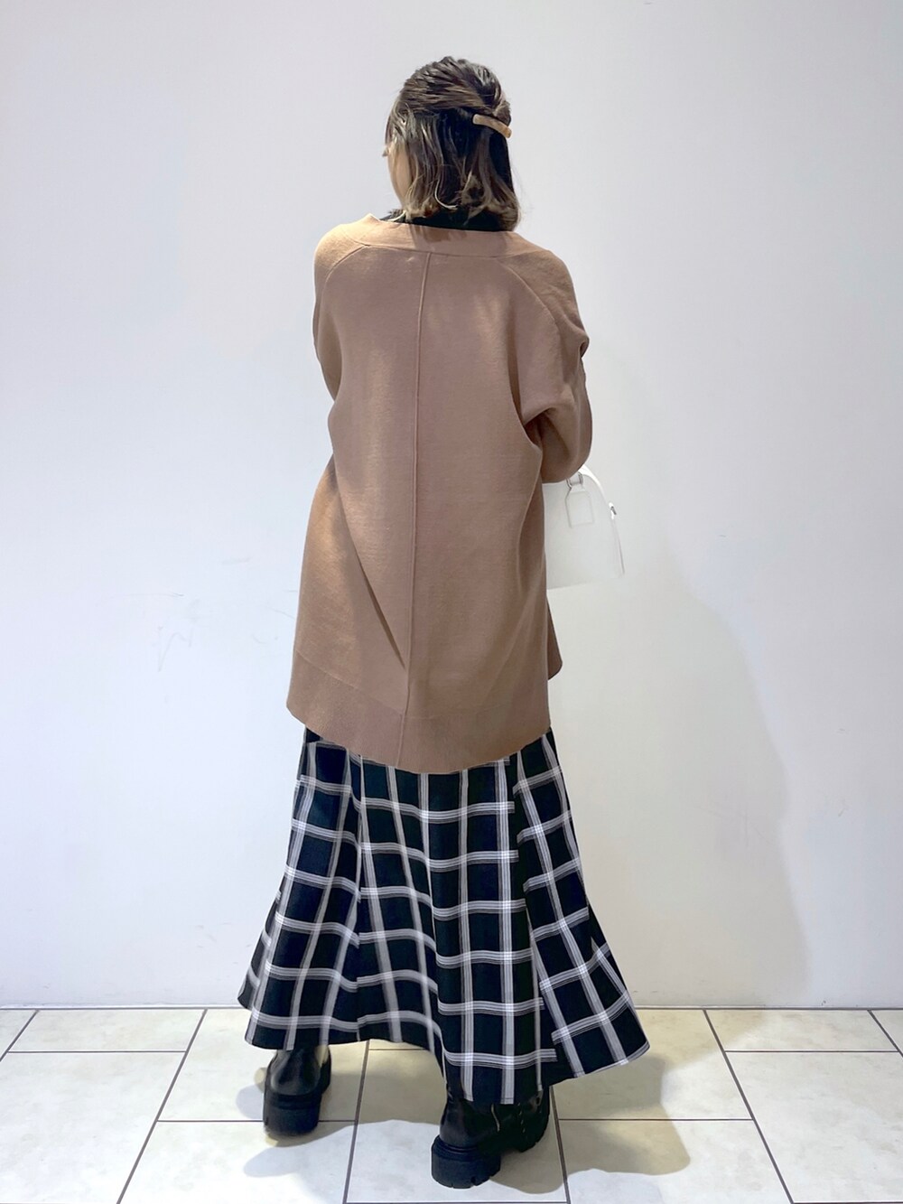 ブラック系のニット/セーター、ブラウン系のニット/セーター、ブラック系のスカートを着用したレディースの秋コーディネートの2枚目の写真