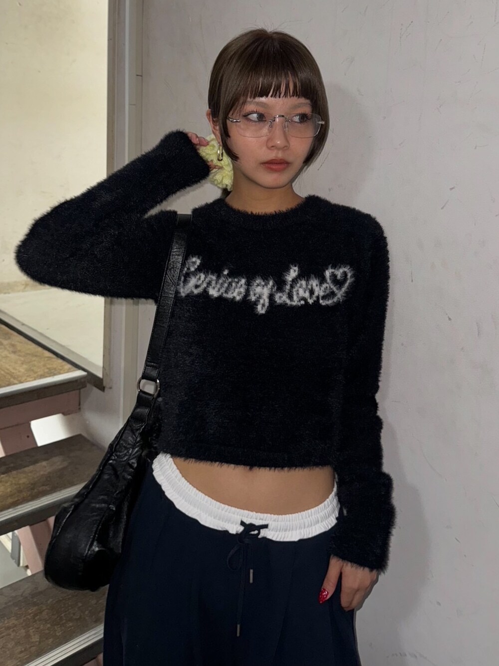 ブラック系のニット/セーター、ブルー系のスラックス、シルバー系のサングラスを着用したレディースの秋コーディネートの3枚目の写真