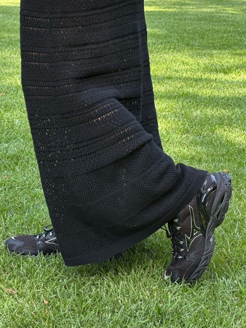 ベージュ系のハンドバッグ、ブラック系のスニーカー、ブラック系のタンクトップを着用したレディースの夏コーディネートの3枚目の写真