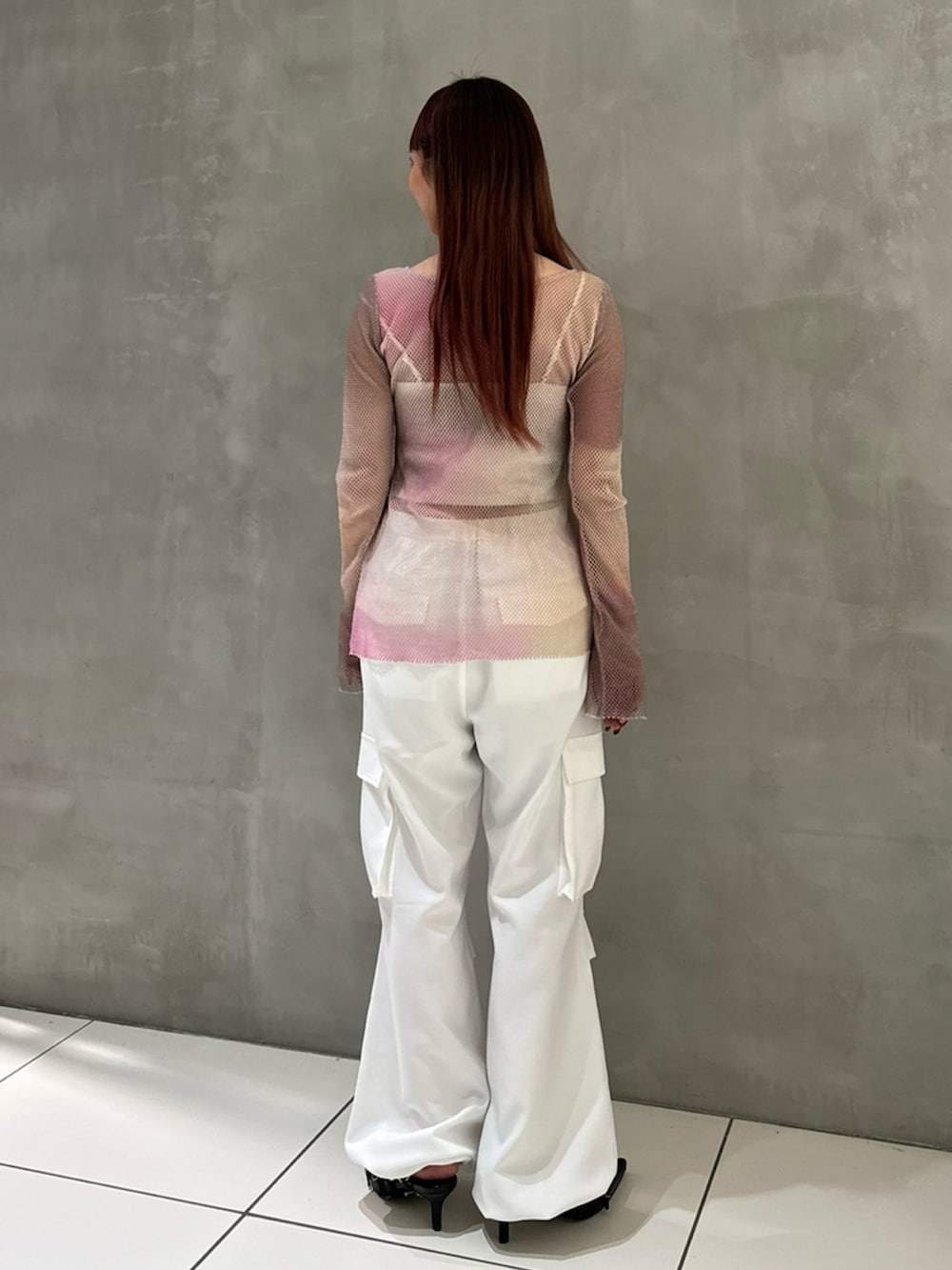 ピンク系のTシャツ/カットソー、ホワイト系のキャミソール、ホワイト系のカーゴパンツを着用したレディースの冬コーディネートの2枚目の写真