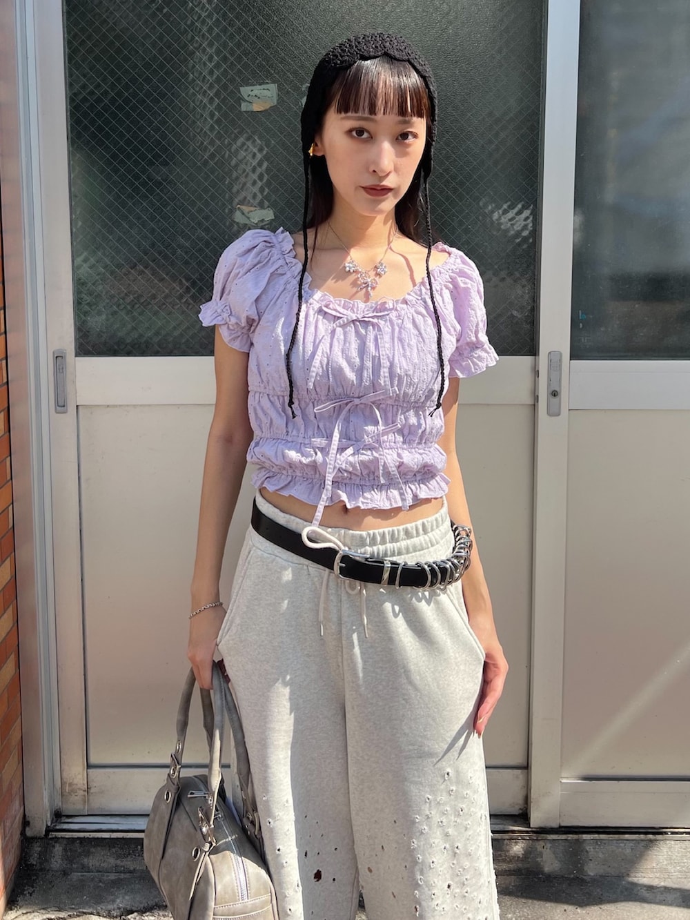 グレー系のハンドバッグ、グレー系のスウェットパンツ、パープル系のシャツ/ブラウスを着用したレディースの夏コーディネートの3枚目の写真