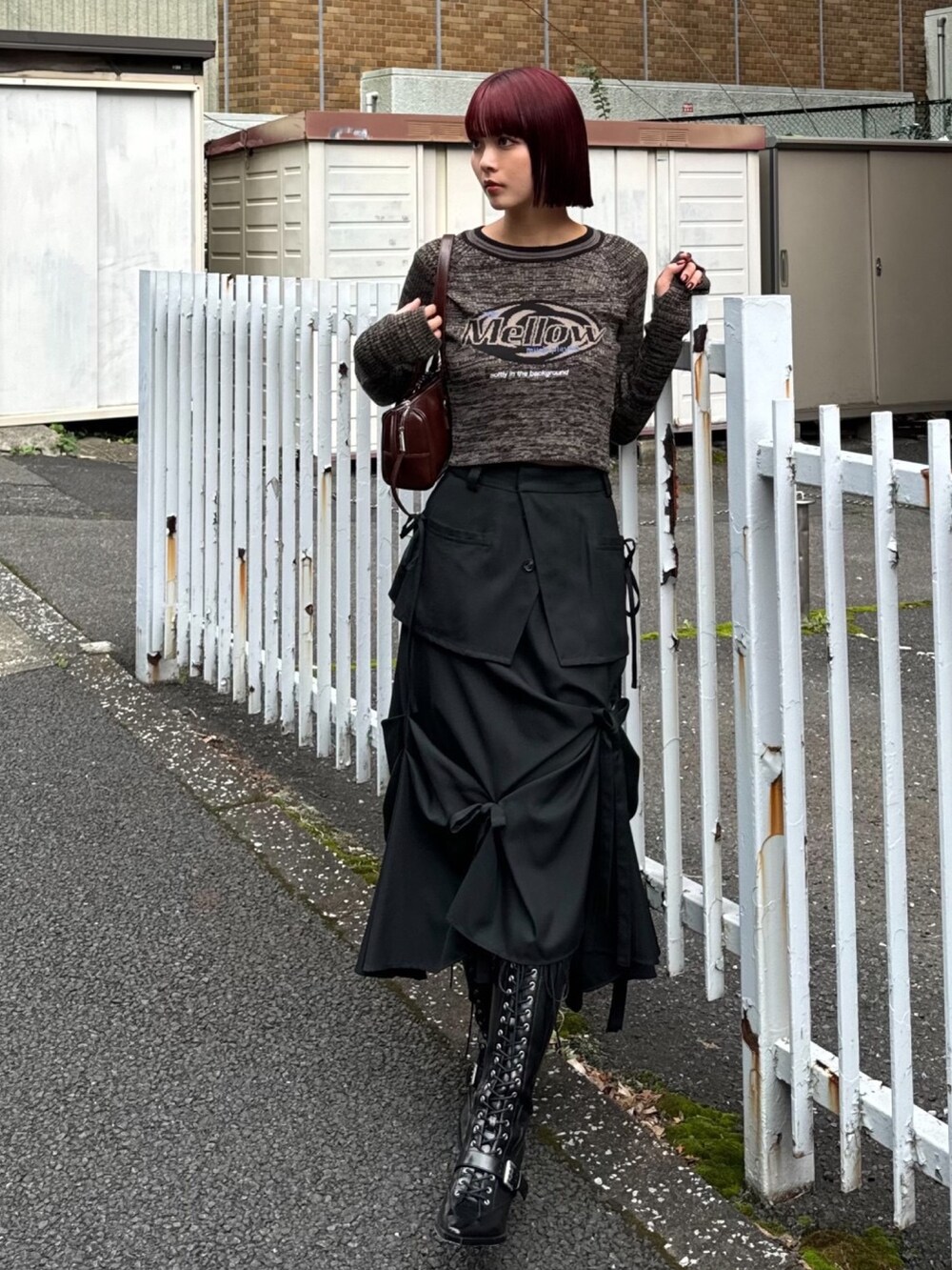 ブラック系のニット/セーター、ブラック系のスカート、ブラック系のブーツを着用したレディースの秋コーディネートの2枚目の写真