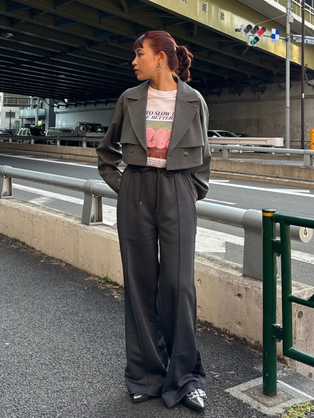 グレー系のトレンチコート、ホワイト系のTシャツ/カットソー、ブラック系のスラックスを着用したレディースの冬コーディネートの4枚目の写真