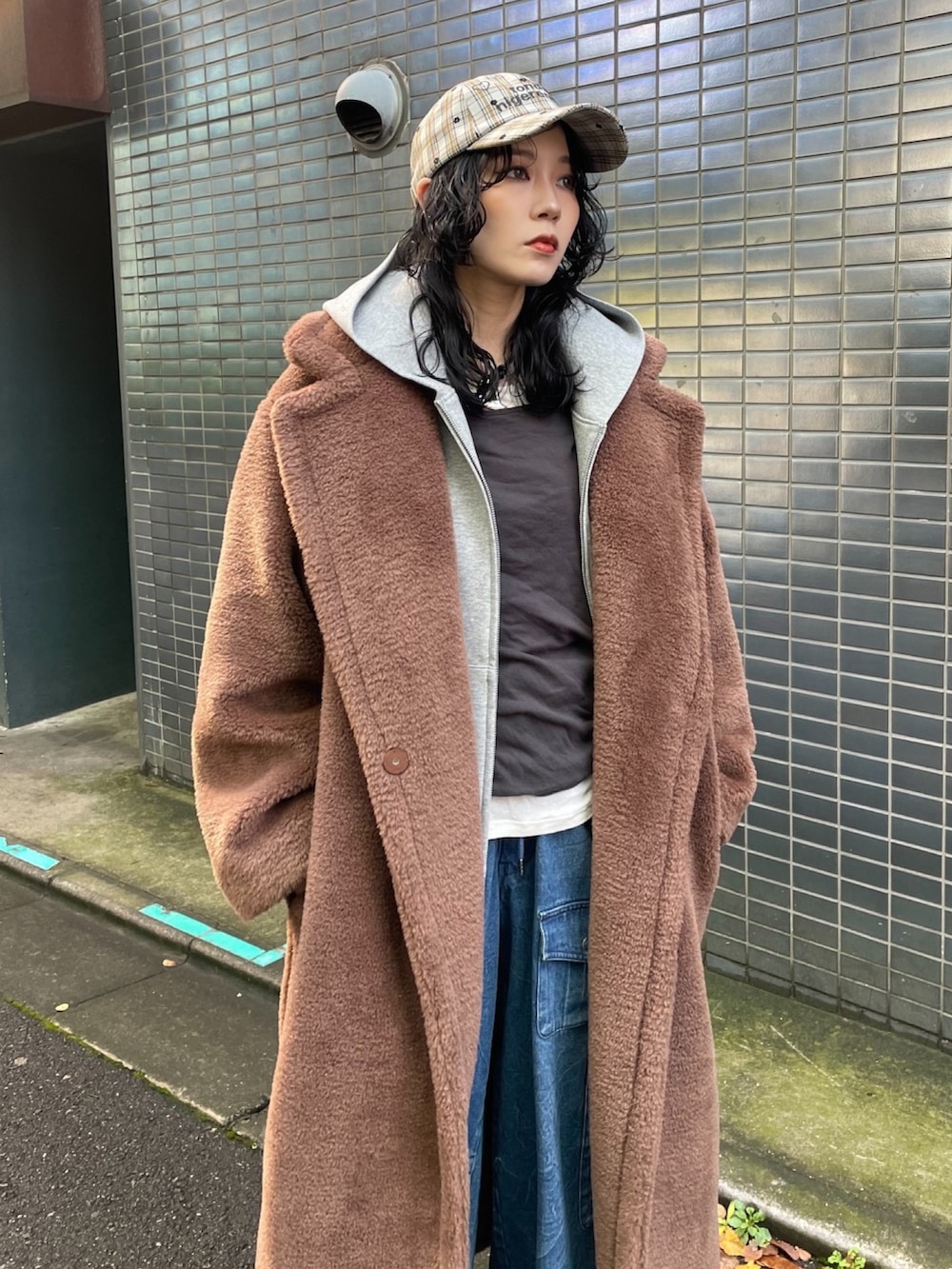 ブラウン系のその他アウター、ブルー系のキャップを着用したレディースの冬コーディネートの2枚目の写真