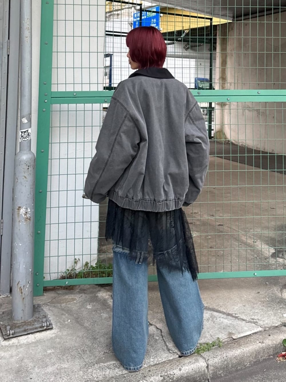 ブルー系のデニムパンツ、ブルー系のパンプス、ブラック系のブルゾンを着用したレディースの冬コーディネートの4枚目の写真