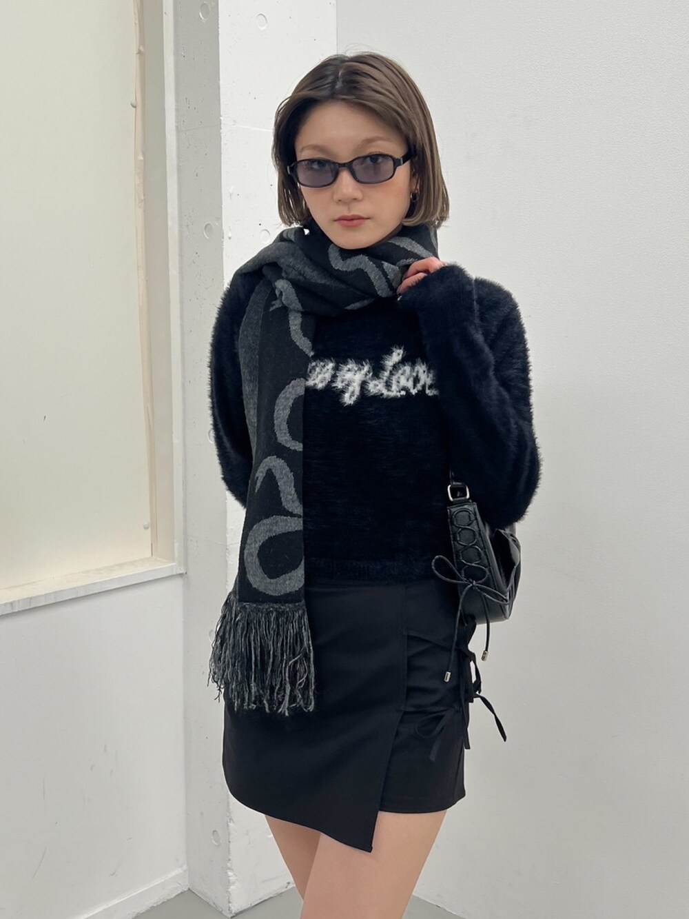 ブラック系のニット/セーター、ブラック系のローファーを着用したレディースの秋コーディネートの3枚目の写真