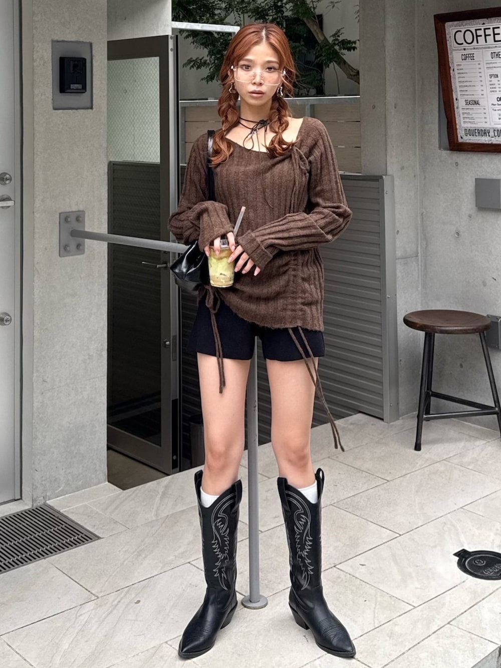 ブラウン系のニット/セーター、ブラック系のスラックス、ブラック系のチョーカーを着用したレディースの秋コーディネートの2枚目の写真