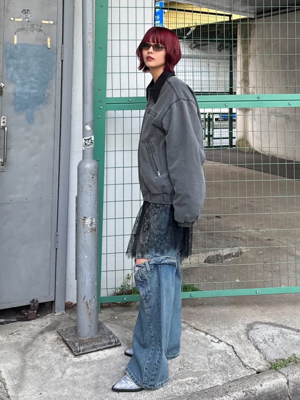 ブルー系のデニムパンツ、ブルー系のパンプス、ブラック系のブルゾンを着用したレディースの冬コーディネートの2枚目の写真