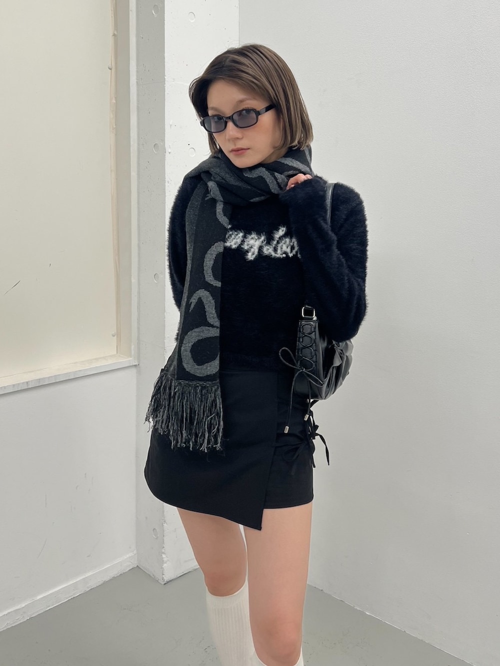 ブラック系のニット/セーター、ブラック系のローファーを着用したレディースの秋コーディネートの2枚目の写真