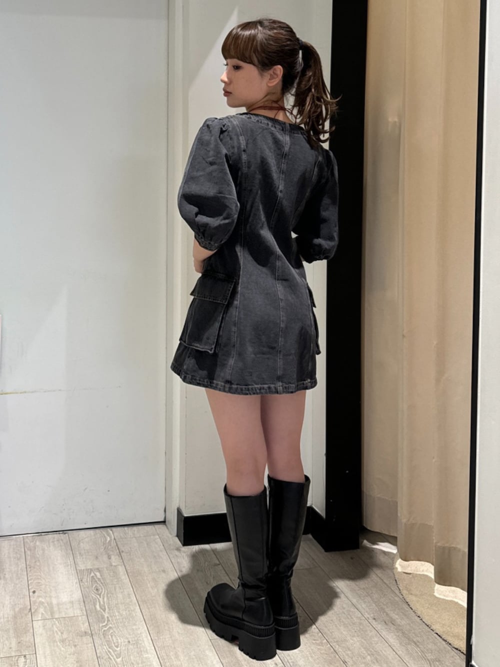 ブラック系のワンピース、ブラック系のブーツ、シルバー系のネックレスを着用したレディースの春コーディネートの3枚目の写真