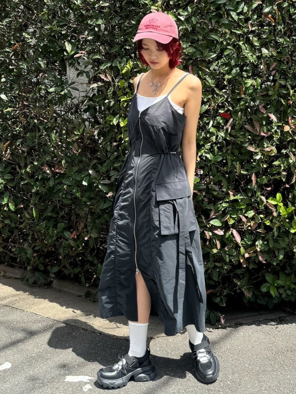 ブラック系のワンピース、グレー系のハンドバッグ、ブラック系のスニーカーを着用したレディースの春コーディネートの2枚目の写真