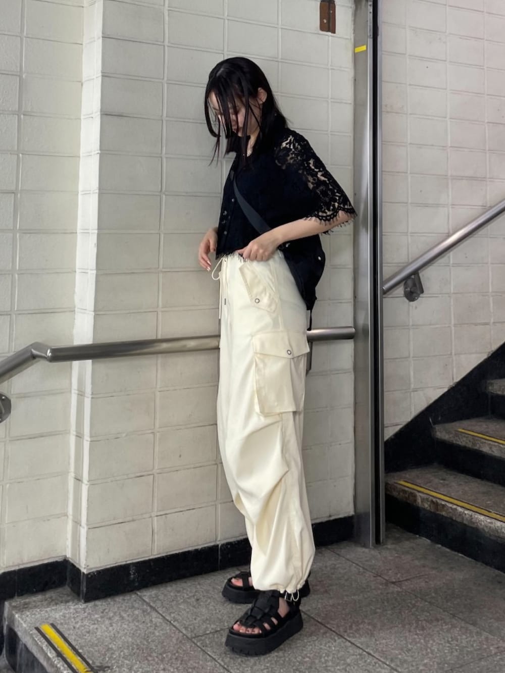 ブラック系のサンダル、ブラック系のシャツ/ブラウス、ホワイト系のスラックスを着用したレディースの夏コーディネートの3枚目の写真