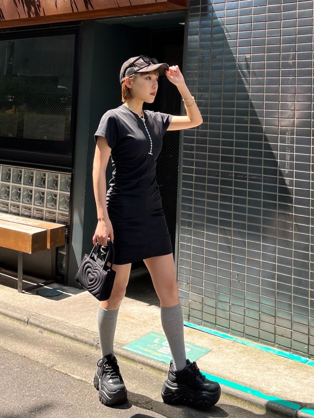 ブラック系のワンピース、ブラック系のサンダル、ブラック系のハンドバッグを着用したレディースの夏コーディネートの3枚目の写真