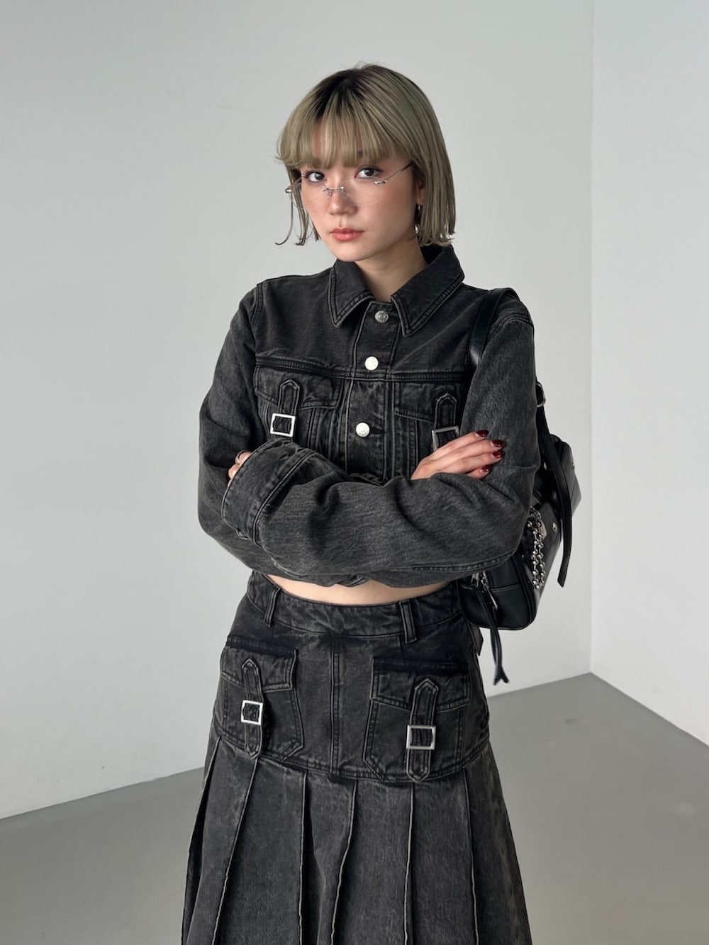 ブラック系のブーツ、ブラック系のデニムスカート、ブラック系のデニムジャケットを着用したレディースの秋コーディネートの3枚目の写真