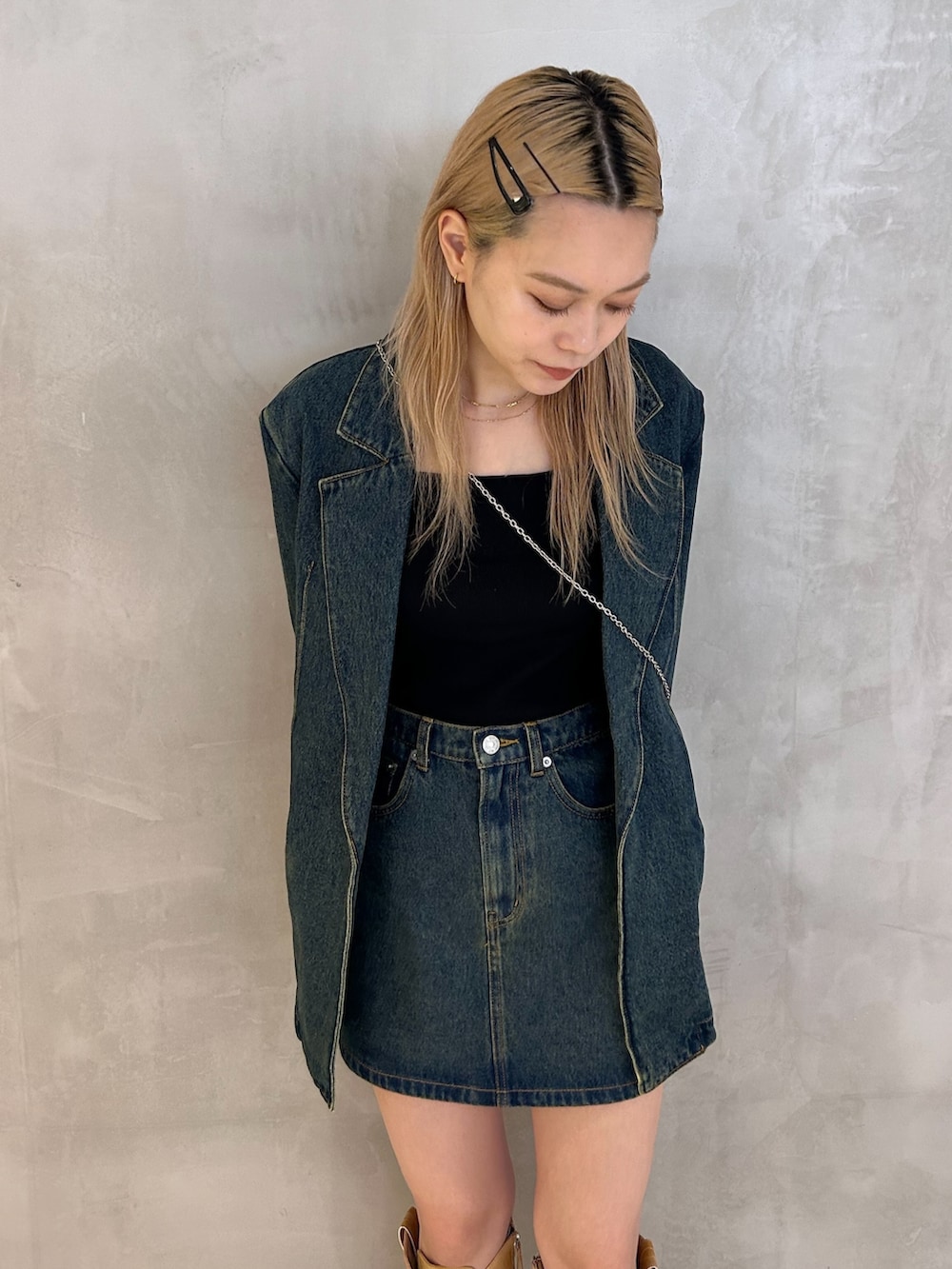 ブルー系のデニムジャケット、ブルー系のデニムスカート、ベージュ系のブーツを着用したレディースの秋コーディネートの2枚目の写真