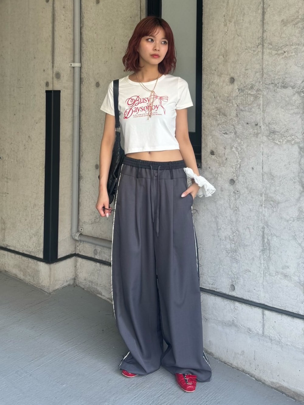 ホワイト系のTシャツ/カットソー、グレー系のスラックス、レッド系のサンダルを着用したレディースの夏コーディネートの2枚目の写真