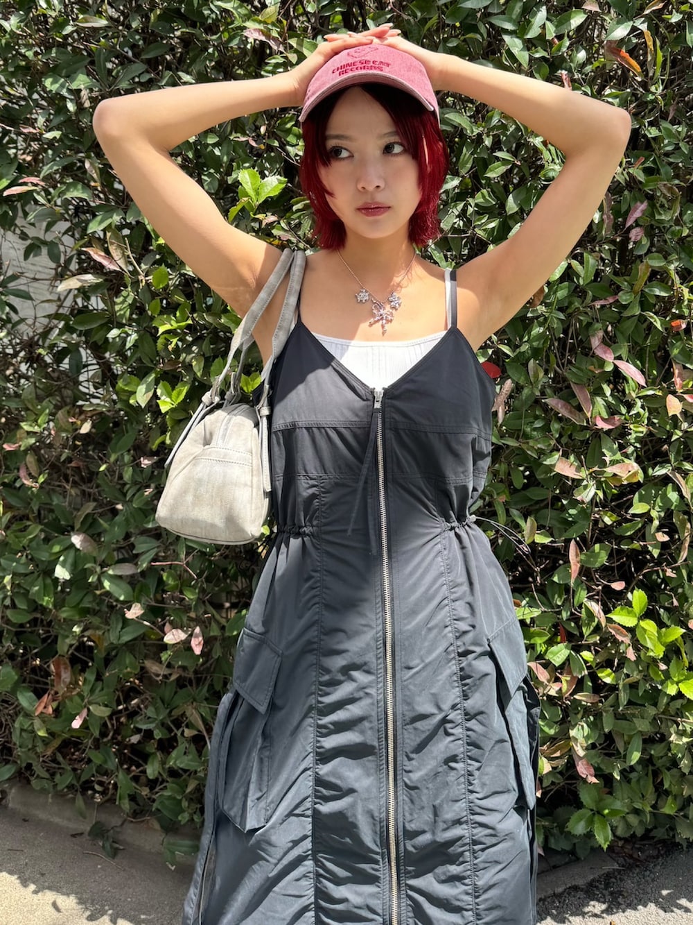 ブラック系のワンピース、グレー系のハンドバッグ、ブラック系のスニーカーを着用したレディースの春コーディネートの3枚目の写真