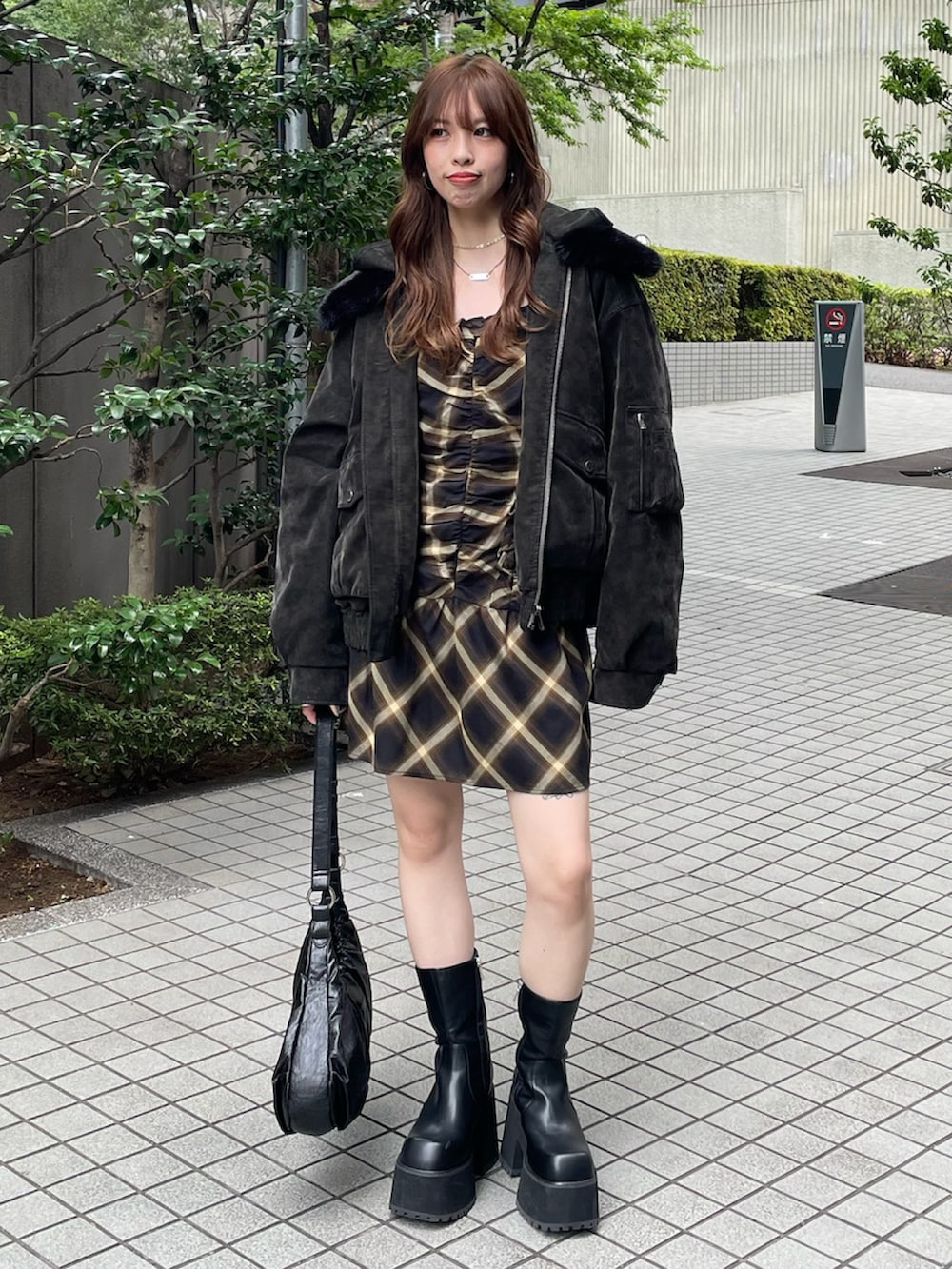 ブラック系のブルゾン、イエロー系のワンピースを着用したレディースの夏コーディネートの2枚目の写真