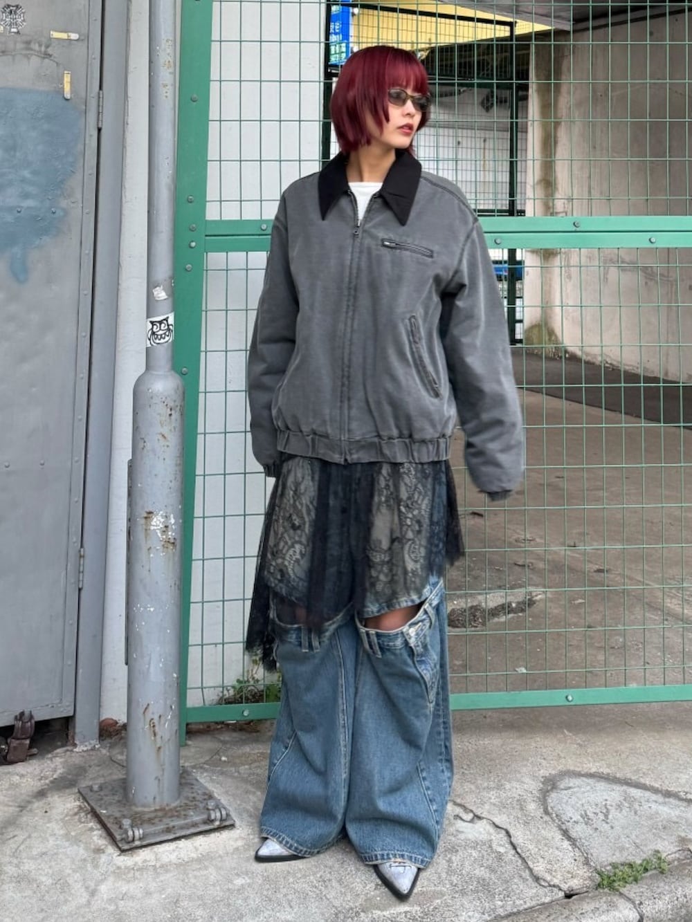 ブルー系のデニムパンツ、ブルー系のパンプス、ブラック系のブルゾンを着用したレディースの冬コーディネートの3枚目の写真