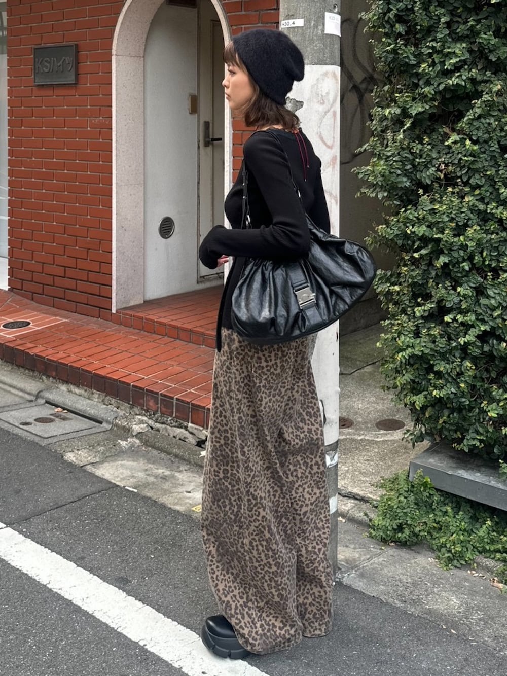 ブラウン系のデニムパンツ、ブラック系のニット/セーター、ブラック系のブーツを着用したレディースの夏コーディネートの2枚目の写真