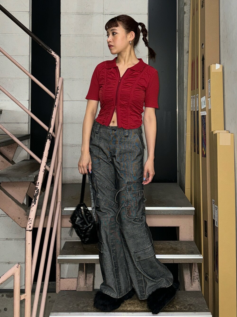 レッド系のTシャツ/カットソー、ブラック系のスラックス、ブラック系のサンダルを着用したレディースの夏コーディネートの2枚目の写真