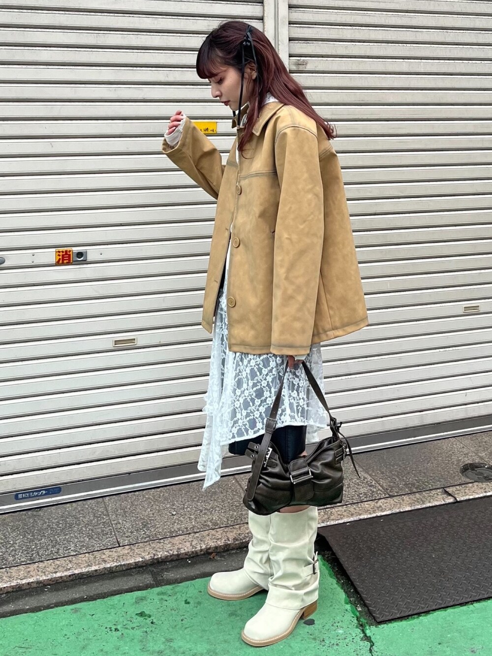 ベージュ系のブルゾン、ホワイト系のワンピース、ブラウン系のハンドバッグを着用したレディースの冬コーディネートの2枚目の写真
