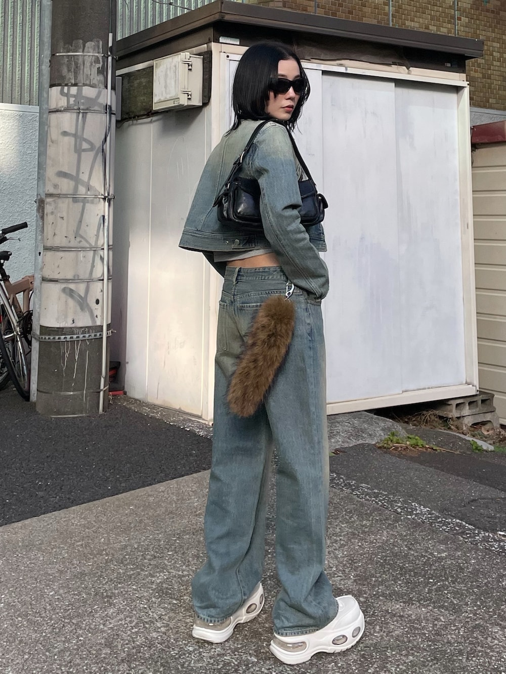 ホワイト系のスニーカー、ブルー系のデニムパンツ、ブルー系のデニムジャケットを着用したレディースの春コーディネートの2枚目の写真