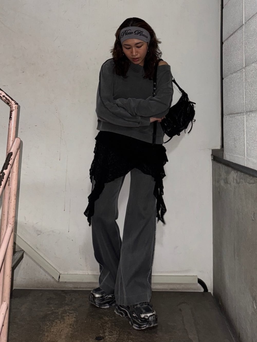 ブラック系のスウェット、グレー系のスラックス、ブラック系のショルダーバッグを着用したレディースの冬コーディネートの2枚目の写真